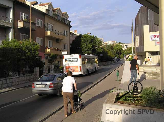 Autobus MHD u obchodního domu mezi tržnicí a nemocnicí.